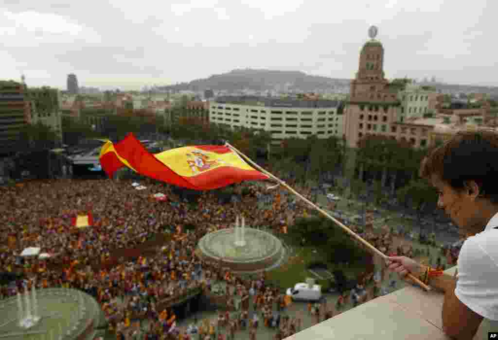 A boy waves a Spanish flag during Spain&#39;s National Day celebrations in the Catalan city of Barcelona, Spain.