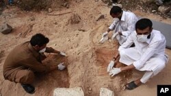 Volunteers dig up corpses in the city of Sirte, October 23, 2011.