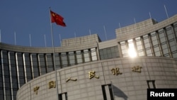 资料照：中国国旗在中国人民银行在北京的总部外飘扬。