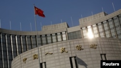 A Chinese national flag flies at the headquarters of the People's Bank of China, the country's central bank, in Beijing, Jan. 19, 2016. 