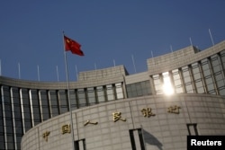 A Chinese national flag flies at the headquarters of the People's Bank of China, the country's central bank, in Beijing, China, Jan. 19, 2016.