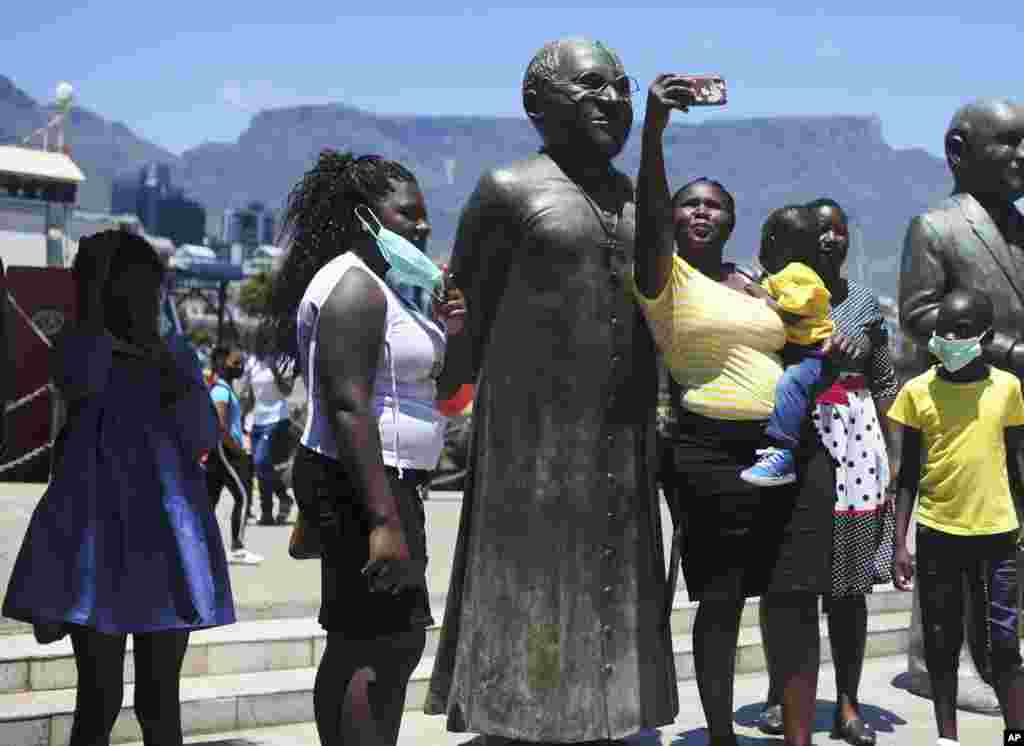 People take photos at a statue of Anglican Archbishop Desmond Tutu at the V&amp;A Waterfront in Cape Town, South Africa.&nbsp;South Africa&#39;s president says Tutu, the country&#39;s Nobel Peace Prize-winning activist for racial justice and LGBT rights and the retired Anglican Archbishop of Cape Town, has died at the age of 90.