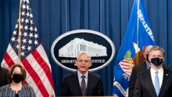 Attorney General Merrick Garland, center, accompanied by Deputy Attorney General Lisa Monaco, left, and FBI Director Christopher Wray, right, speaks at a news conference at the Justice Department in Washington, Nov. 8, 2021.