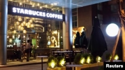 Para pekerja mempersiapkan pembukaan kedai kopi Starbucks di Ho Chi Minh City, Vietnam, akhir Juli. 