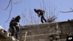 FILE - Militants from the Kurdistan Workers Party, or PKK, run as they attack Turkish security forces in Nusaydin, Turkey, March 1, 2016. PKK rebels are suspected to be behind the latest attack in Diyarbakir province. 