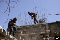 FILE - Militants from the Kurdistan Workers Party, or PKK, run as they attack Turkish security forces in Nusaydin, Turkey, March 1, 2016.