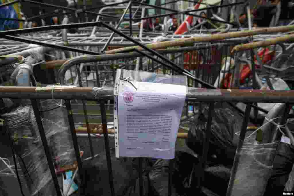 A injunction notice is displayed on a barricade set up by pro-democracy protesters at the main protest site in the Admiralty district Hong Kong, Dec. 9, 2014.