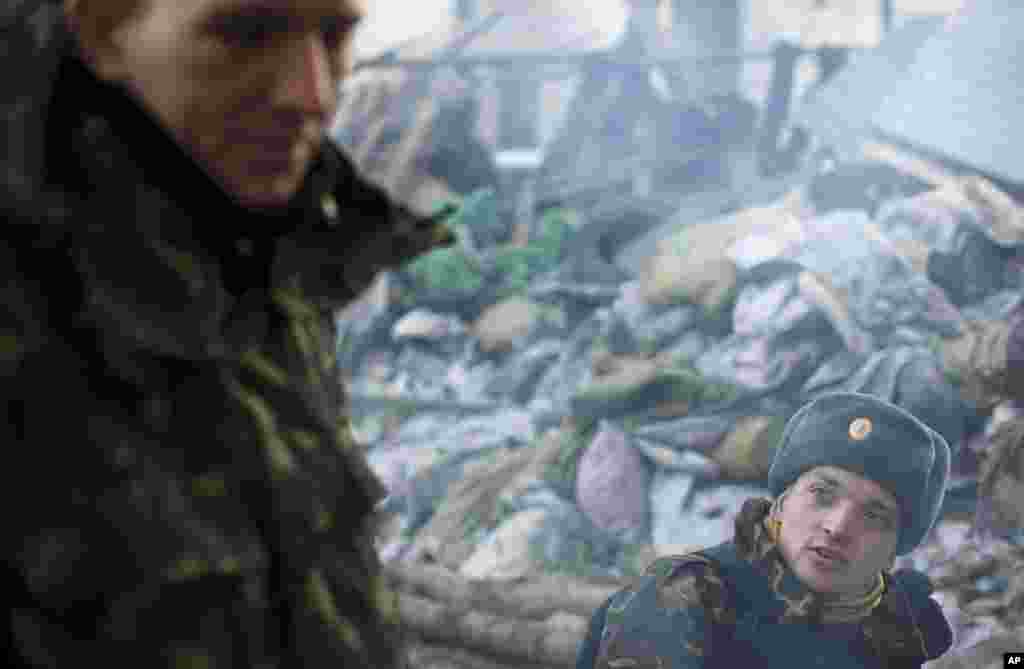 Members of a self defense volunteer group chat as they guard a barricade in Kyiv's Independence Square, March 14, 2014.