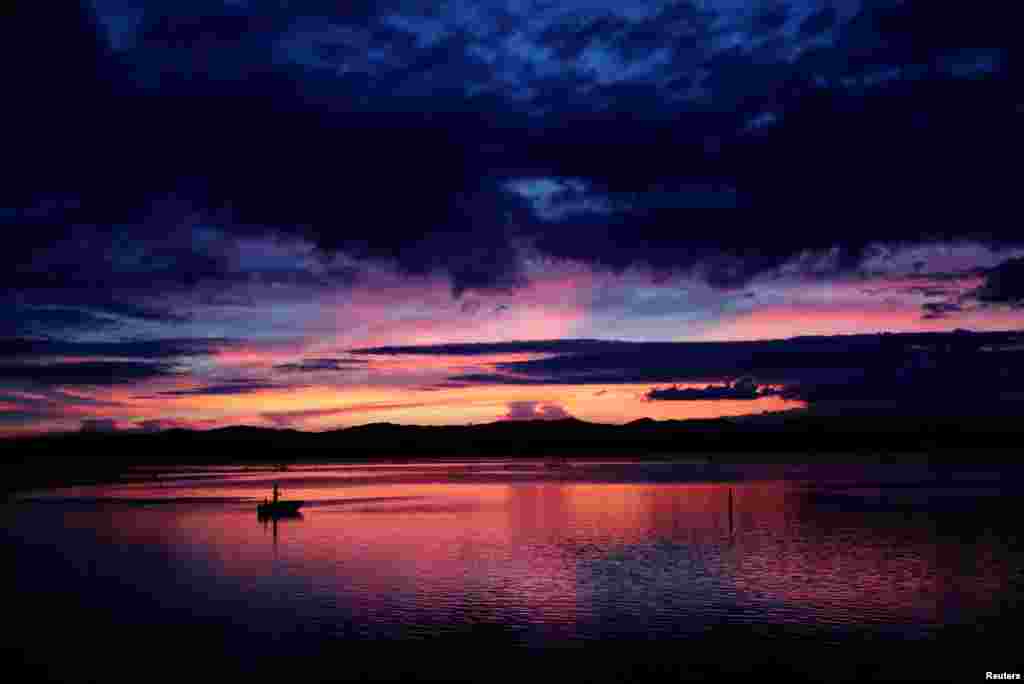 A man fishes on a boat at Lake Hamana in Hamamatsu, Shizuoka Prefecture, Japan.