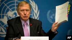 Michael Kirby, chairperson of the commission of Inquiry on Human Rights in the Democratic People's Republic of Korea, shows the commission's report during a press conference at the United Nations in Geneva, Switzerland, Feb. 17, 2014.