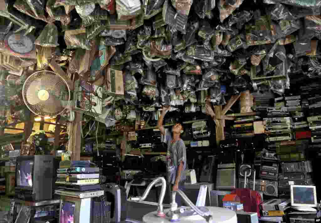 A customer looks through items at a flea market on the outskirts of Jakarta, Indonesia.