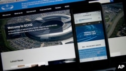 FILE - This photo-illustration shows a web page for GCHQ, the British governments communications and electronic surveillance headquarters, and The Security Service (MI5), the governments internal security service, on a computer and smartphone in London, Nov. 25, 2016. The GCHQ took the unusual step Friday of releasing a statement calling the claims of it having spied on President Donald Trump “nonsense.”