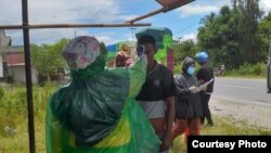 Petugas dinas kesehatan kabupaten Poso melakukan pemeriksaan suhu tubuh terhadap seorang warga di desa Mayoa, Pamona Selatan Kabupaten Poso yang berbatasan dengan provinsi Sulawesi Selatan, 26 Maret 2020. (Foto: Humas Pemkab Poso)