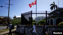 FILE PHOTO: People pass by Canada's Embassy in Havana, Cuba, April 16, 2018.