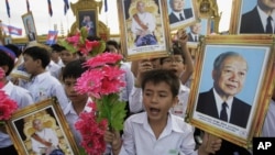 Cambodian students hold portraits of former King Norodom Sihanouk during an Independence Day celebration in Phnom Penh, Cambodia, Nov. 9, 2011.