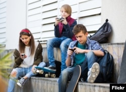 FILE -- Young people using smartphones. (Photo courtesy Kuvituskuvat via Flickr)