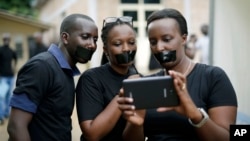 Journalists with tape on their mouths gather on the occasion of World Press Freedom Day, Bujumbura, Burundi, May 3, 2015. 
