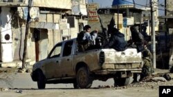 FILE - This undated file image posted on a militant website Jan. 14, 2014, shows fighters from the al-Qaida linked Islamic State of Iraq and the Levant (ISIL) patrolling in Raqqa, Syria.