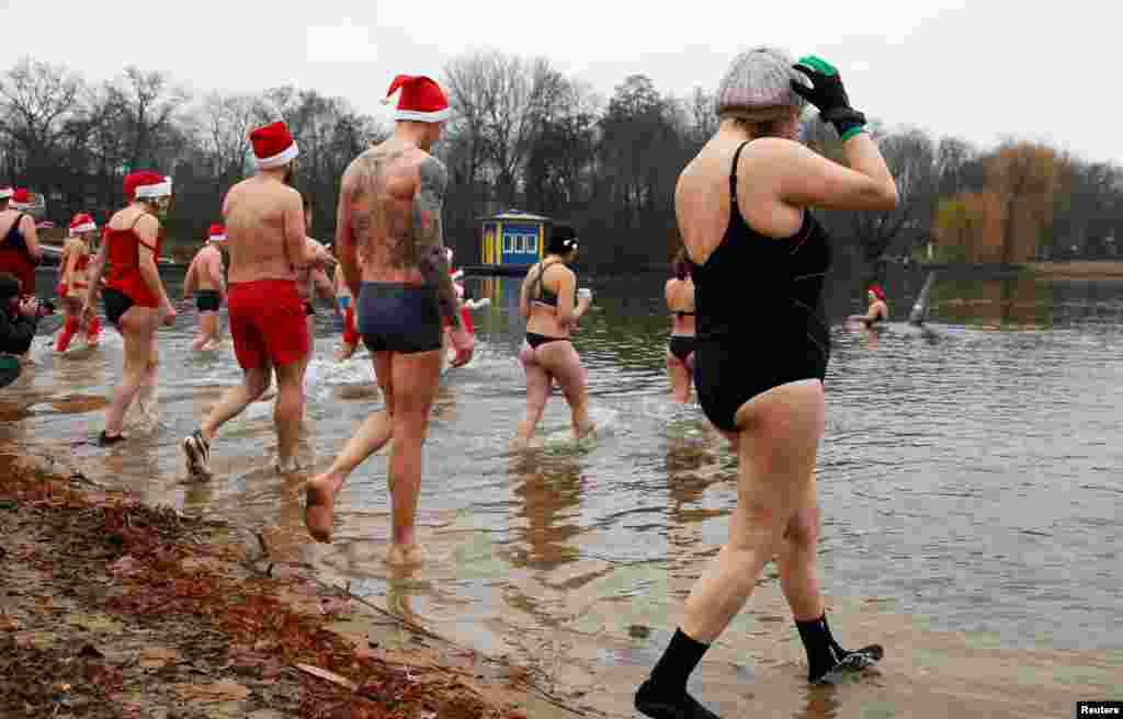 Los miembros del club de nadadores de hielo Berliner Seehunde (sellos de Berl&#237;n) celebran la fundaci&#243;n de la playa p&#250;blica para nadar del lago Oranke con el tradicional evento de nataci&#243;n del d&#237;a de Navidad en Berl&#237;n, Alemania. [Reuters].