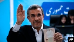 Mantan Presiden Iran beraliran garis keras Mahmoud Ahmadinejad menunjukkan dokumen yang ia bawa saat mendaftar sebagai kandidat dalam pilpres Iran mendatang di Kantor Kementerian Dalam Negeri di Teheran, pada 2 Juni 2024. (Foto: AP/Vahid Salemi) 