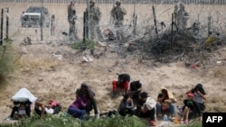 Migrante koji traže azil u Sjedinjenim Državama nadzire Nacionalna garda Teksasa dok ostaju na obali Rio Grandea nakon što su prešli iz Ciudad Juareza, država Chihuahua, Meksiko, 4. juna 2024.