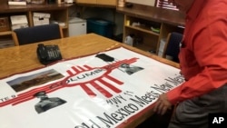 In this Oct. 3, 2018 photo, Columbus, N.M., Mayor Esequiel Salas shows off a new welcoming banner that acknowledges that Pancho Villa raided the town in 1916. 