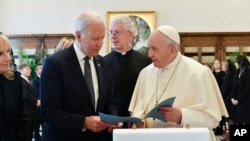 President Joe Biden exchanges gifts with Pope Francis as they meet at the Vatican, Oct. 29, 2021.