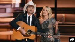 FILE - Hosts Brad Paisley, left, and Carrie Underwood speak at the 50th annual CMA Awards at the Bridgestone Arena in in Nashville, Tennessee, Nov. 2, 2016.