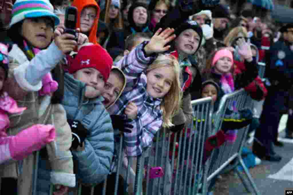 Young spectators wave to Santa Claus as he rolls down 7th Avenue during the Macy's Thanksgiving Day Parade, Thursday, Nov. 24, 2011, in New York. A jetpack-wearing monkey and a freakish creation from filmmaker Tim Burton are two of the big new balloons th