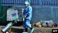 Una enfermera de la Unidad de Cuidados Intensivos del Hospital Escolar empuja un tanque de oxígeno para un paciente presuntamente infectado con el nuevo coronavirus en Tegucigalpa, el 17 de julio de 2020.