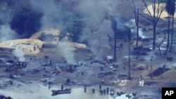 FILE - Smoke rises from an illegal oil refinery in Ogoniland, outside Port Harcourt, Nigeria's Delta region, March 24, 2011. Nigeria is stepping up its efforts to curb crude oil theft, saying it has shut down some illegal refineries.