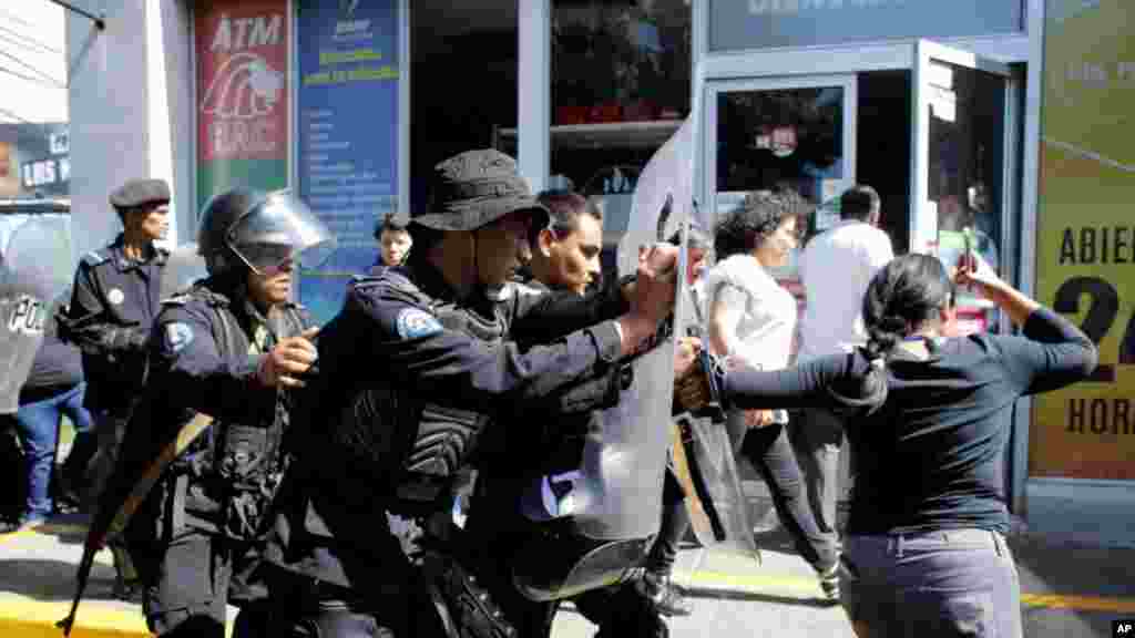 Agentes antidisturbios desalojan a periodistas de la entrada del edificio sede de la jefatura de la Policía Nacional, en Managua, el 30 de septiembre de 2019.&nbsp;