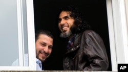 FILE - In this June 5, 2015 file photo, Abu Wa'el Dhiab, from Syria (r) and Adel bin Muhammad El Ouerghi, of Tunisia, both freed Guantanamo Bay detainees, look out the window of their shared home in Montevideo, Uruguay. Abu Wa'el Dhiab, who disappeared in June 2016 in Uruguay, setting off alarm bells in neighboring countries and recriminations in Washington, has reappeared in Venezuela according to Uruguay's Foreign Minister Rodolfo Nin Novoa on Wednesday, July 27, 2016.