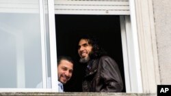 Abu Wa'el Dhiab, de Siria (der.) y Adel bin Muhammad El Ouerghi, de Túnez, exdetenidos de Guantánamo en la ventana del apartamento que compartían en Uruguay, antes de que Dhaib huyera del país y reapareciera en Venezuela.