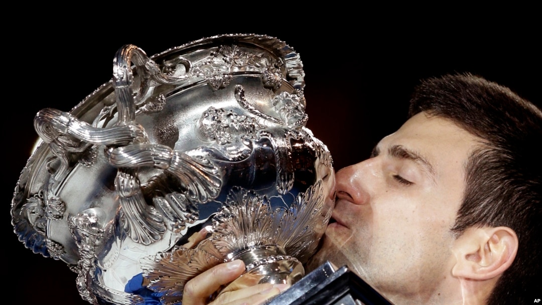 Novak Djokovic dari Serbia mencium piala kemenangan final Australia Terbuka, Februari 2015. (AP/Bernat Armangue)