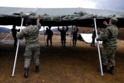 Soldiers put up tents for migrants at the Lipa camp outside Bihac, Bosnia, Jan. 1, 2021.