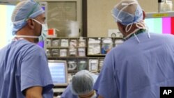 Jazmine Raygoza is prepared for Lap-Band surgery by anesthesiologist Dr. Andrea Grilli (C) Surgical First Assistant Tony Covello (R) and Dr. Michael Snyder (L) at Rose Medical Center in Denver June 20, 2011 . After trying multiple diets and exercise, Jazm