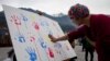 FILE - A Tibet supporter places his palm print on a banner during an event organized by Students for a Free Tibet to show solidarity with Tibetan political prisoners released in 2015 from Chinese jails in Dharmsala, India, Dec. 26, 2015. 