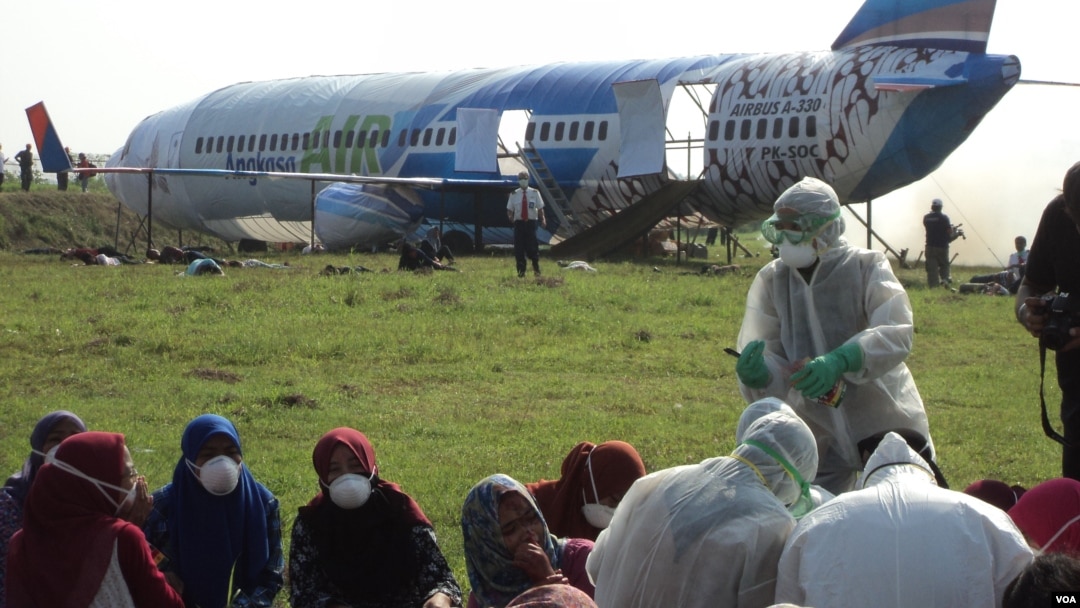 Simulasi di Bandara Adi Soemarmo Solo dengan tim medis khusus memeriksa kondisi penumpang yang terjangkit virus menular mematikan (23/3). (VOA/Yudha Satriawan)
