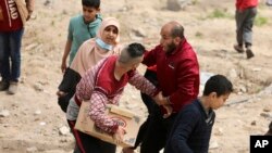 Palestinci žure da pokupe humanitarnu pomoć koja je poslana iz aviona, 17. mart 2024.