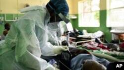 A health worker attends to a COVID-19 patient at Queen Elizabeth Central Hospital COVID-19 male ward in Blantyre, Malawi, Jan. 30, 2021