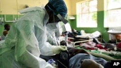 A health worker attends to a COVID-19 patient at Queen Elizabeth Central Hospital COVID-19 male ward in Blantyre, Malawi, Jan. 30, 2021