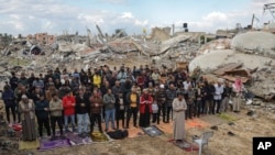 Palestinians perform Friday prayers near the ruins of a mosque destroyed by Israeli airstrikes in Khan Younis, Gaza Strip. (AP Photo/Jehad Alshrafi)