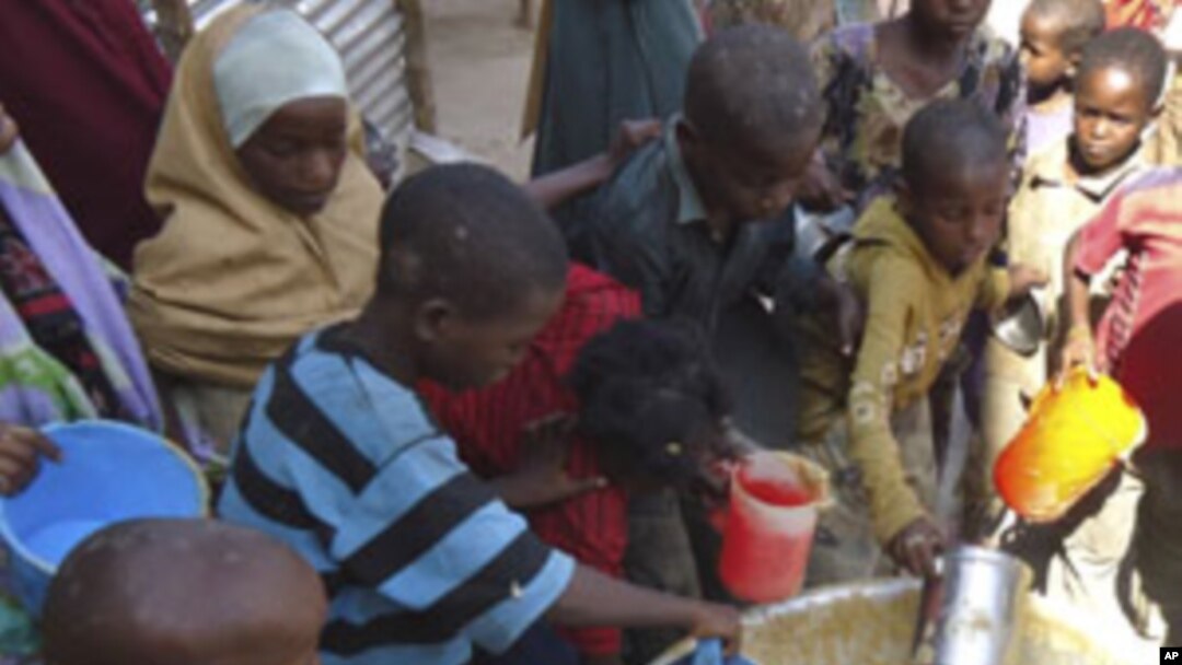 Children from southern Somalia get cooked food at a local NGO's compound in Mogadishu, Somalia, Sept.14, 2011.