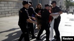 Spanish riot police try to take away a banner from pro-independence supporters during a protest near Spanish parliament in Madrid, Sept. 30, 2014.