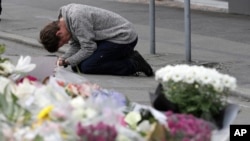 A mourner prays near the Linwood mosque in Christchurch, New Zealand, Tuesday, March 19, 2019