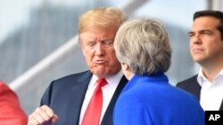 Le président américain Donald Trump, à gauche, en pleine conversation avec la Première ministre britannique Theresa May lors du sommet de l'OTAN à Bruxelles, le 11 juillet 2018. 