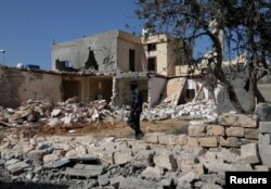 A security member inspects the site of an overnight air strike, which hit a residential district in Tripoli, Libya, Oct. 14, 2019.