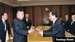 30일 방북 중인 중국 공산당 대표단으로부터 시진핑 공산당 총서기의 친서를 전달받은 김정은 북한 국방위원회 제1위원장(왼쪽).