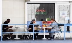 Patrons dine outdoor in Los Angeles, California, July 2, 2020, a day after new regulations came into effect banning all indoor dining as coronavirus cases statewide hit record highs.